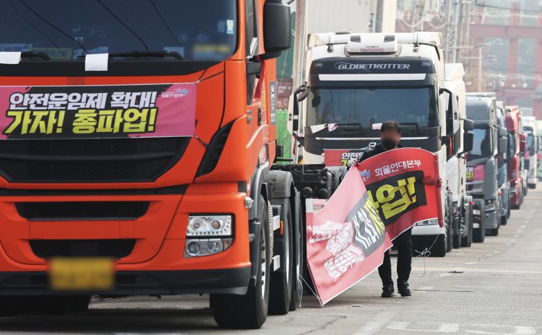 2022년 12월 9일 오후 경기 의왕시 내륙컨테이너기지 앞에서 민주노총 공공운수노조 화물연대 소속의 한 조합원이 화물차에 걸려 있던 총파업 관련 현수막을 떼어 내고 있다. /조선DB