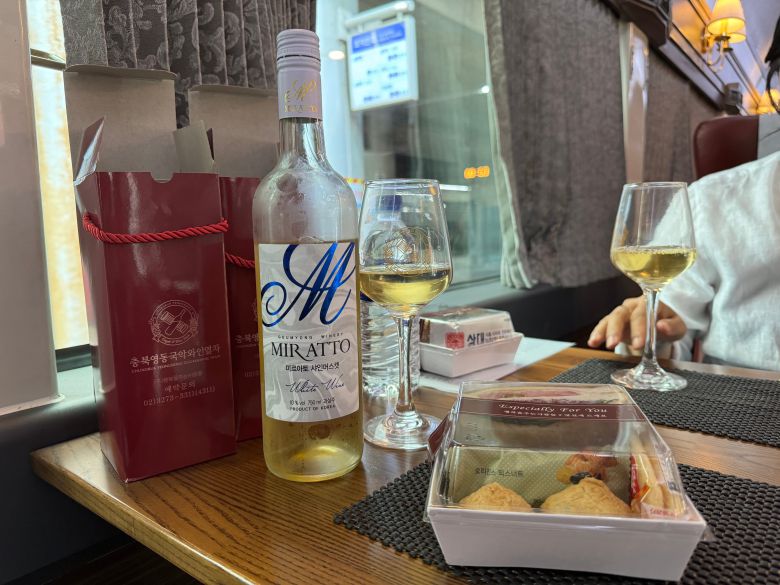 지난 24일 오전 서울역에서 영동역으로 가는 영동 국악와인열차 3호칸 2인석에 충청북도 영동 용산면에서 생산한 '미르아토 샤인머스캣' 화이트 와인과 와인잔, 샌드위치가 놓여있다. /박지윤 기자