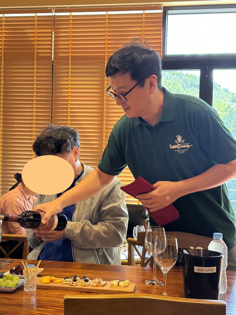 지난 24일 오후 충청북도 영동군 농가형 와이너리 '컨츄리 와인' 시음 공간에서 김덕현 대표가 영동에서 생산한 '컨츄리 캠벨 스위트' 레드 와인을 와인잔에 따르고 있다. /박지윤 기자