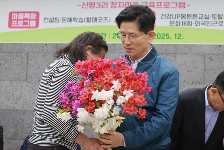 국민의힘 김문수 대선 후보가 4일 한센인 마을인 경기도 포천시 장자마을을 방문해 주민으로부터 꽃다발을 받고 있다. /연합뉴스