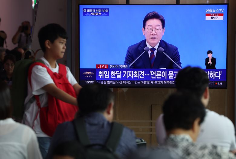 이재명 대통령의 첫 기자회견이 진행된 3일 중구 서울역에서 시민들이 방송을 지켜보고 있다. /연합뉴스