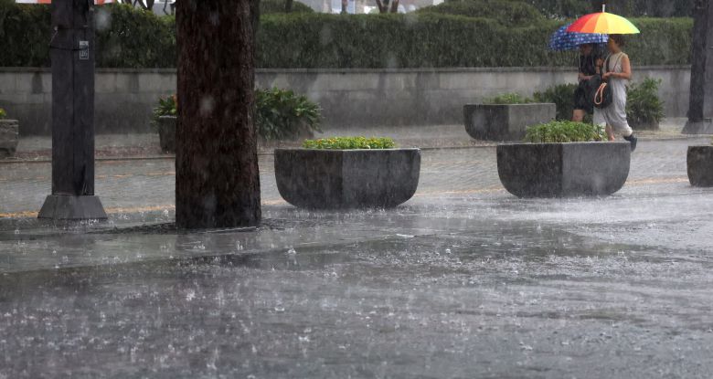 전북 전 지역에 호우특보가 발효된 17일 전북 전주시 한옥마을 태조로에서 우산을 쓴 시민들이 발걸음을 재촉하고 있다. /뉴스1
