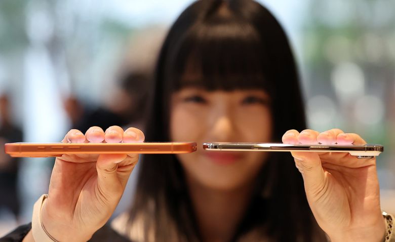 서울 중구 명동 애플스토어에서 한 시민이 애플의 스마트폰 '아이폰 에어'(오른쪽)와 '아이폰17 프로'의 두께를 비교하고 있다./뉴스1