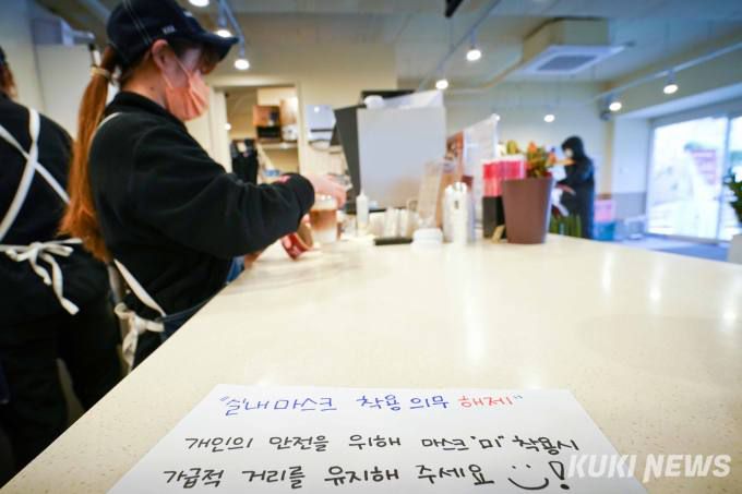 실내 마스크 의무 착용이 해제된 지난 1월 오후 서울 시내 한 프랜차이즈 카페에서 마스크 착용 관련 안내문을 붙이고 있다. 실내마스크 착용 의무가 해제됐지만, 종업원과 손님은 마스크를 쓰고 있다.   사진=임형택 기자