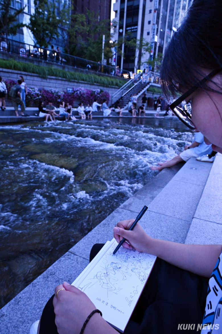 '소녀화가'  가마솥 더위가 이어지고 있는 가운데 휴일인 12일 저녁 서울 중구 청계천을 찾은 한 학생이 펜으로 청계천의 여름 풍경을 담고 있다.