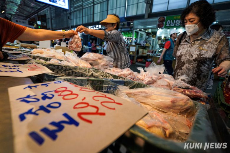 초복을 이틀 앞둔 18일 서울 구로시장에 위치한 한 정육점에서 점원이 생닭을 들어보이고 있다.