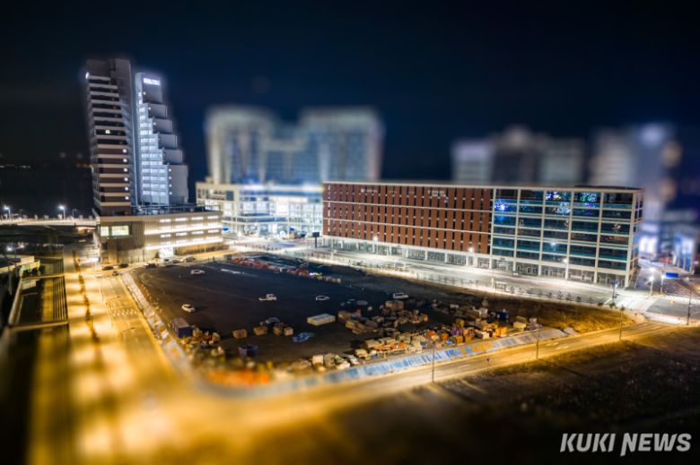 지난 19일 새벽 경기 시흥시 정왕동 상공에서 바라본 거북섬 풍경. 화물차와 승용차, 각종 건설자재들이 놓인 건설현장 너머로 거북섬 상가들이 늘어서 있다.