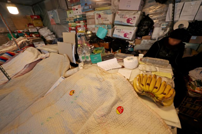 서울의 체감 온도가 영하 20도까지 떨어지는 등 전국 곳곳에 한파 특보가 발효 중인 26일 오전 서울 송파구 가락농수산물종합도매시장의 한 점포에서 상인이 과일을 이불로 덮고 있다.