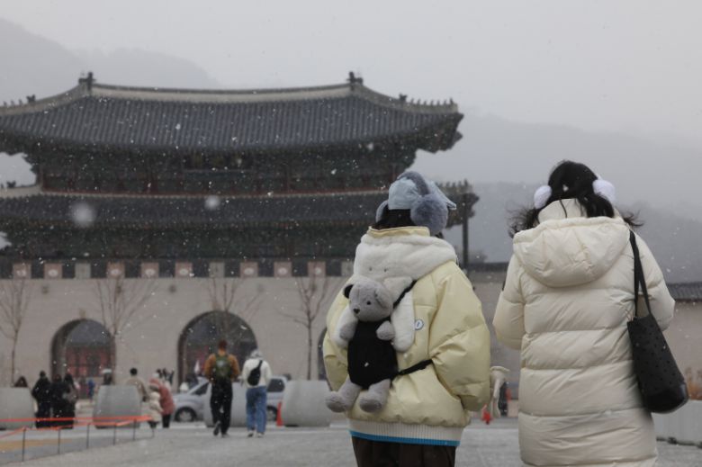 12일 서울 광화문광장 일대에 눈이 내리고 있다.