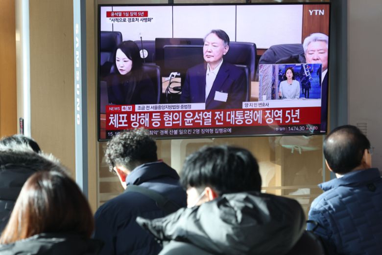 16일 서울역 대합실에서 시민들이 고위공직자범죄수사처(공수처) 체포 방해 등 혐의로 기소된 윤석열 전 대통령에 대한 1심 선고 공판 생중계를 보고 있다. 연합뉴스