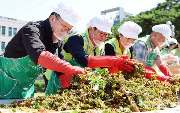 대전시는 23일 시청 남문광장에서 '여름김장 나눔 대봉사' 행사를 열고 무더운 여름철 취약계층의 건강한 식생활을 돕기 위해 열무김치와 오이소박이 1000박스를 정성스럽게 담가 전달했다고 밝혔다. 사진은 이장우 대전시장(왼쪽)이 김치를 담그고 있다. [사진제공=대전시]