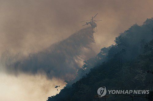 (대구=연합뉴스) 윤관식 기자 = 28일 오후 2시 1분께 대구 북구 노곡동 함지산에서 발생한 산불이 확산하는 가운데 헬기가 산불을 끄고 있다. 2025.4.28 psik@yna.co.kr