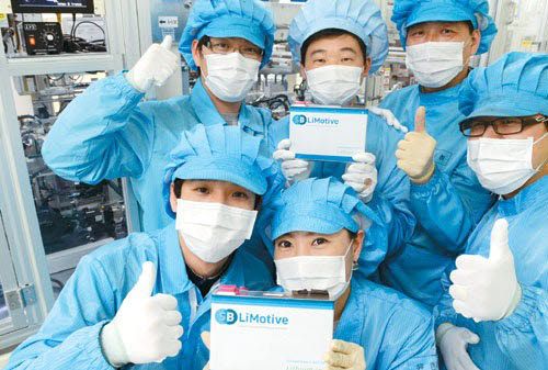 삼성SDI 울산 공장 내 전기차 배터리 생산라인 연구원들이 리튬이온 배터리 팩을 들고 엄지손가락을 치켜세우고 있다