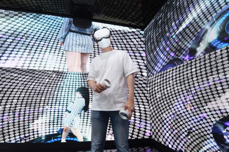 SK텔레콤 부스에서 관계자가 메타버스 플랫폼 이프랜드의 HDM(Head Mounted Display) 체험을 하고 있다.