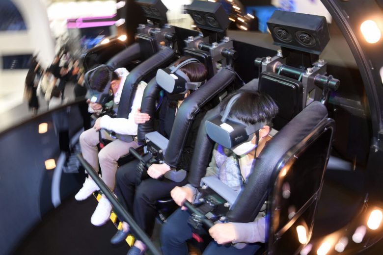 SK텔레콤 부스에서 관람객이 4D 메타버스 체험을 하고 있다.