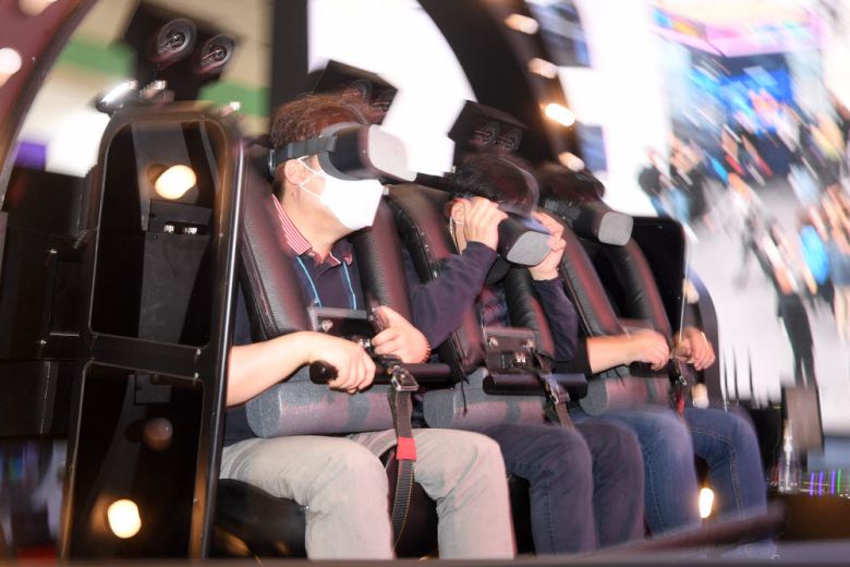 SK텔레콤 부스에서 관람객이 4D 메타버스 체험을 하고 있다.