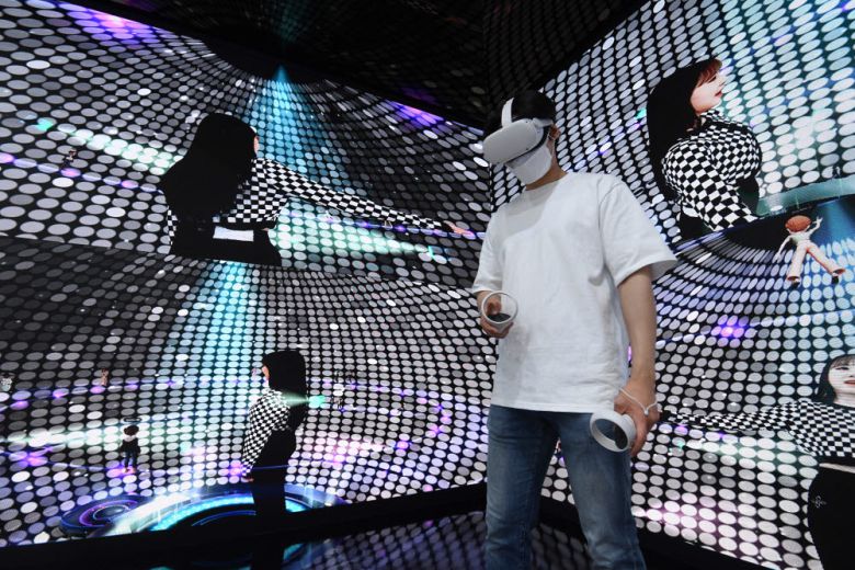 SK텔레콤 부스에서 관계자가 메타버스 플랫폼 이프랜드의 HDM(Head Mounted Display) 체험을 하고 있다.