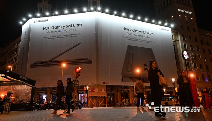 스페인 바르셀로나에서 열리는 세계 최대 이동통신 박람회 모바일 월드 콩그레스 (MWC) 2024 개막을 사흘 앞둔 23일(현지시간) 밤 카탈루냐 광장 인근 건물 외벽에 삼성 갤럭시S24 대형 옥외 광고물이 내걸려 있다. 삼성전자는 MWC2024 개막에 맞춰 삼성전자는 스페인 바르셀로나의 중심지 카탈루냐 광장에서 갤럭시S24 시리즈를 체험할 수 있는 '갤럭시 익스피리언스 스페이스' 체험관을 29일까지 운영한다. 바르셀로나(스페인)=이동근기자 foto@etnews.com
