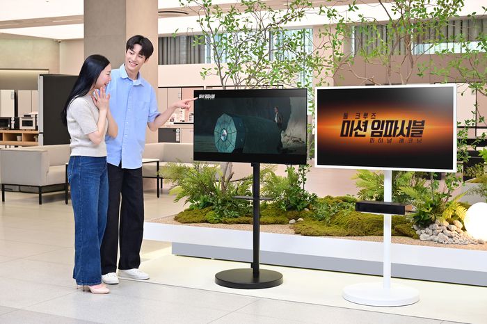 삼성전자 모델이 2025년형 OLED TV, 더 프레임 TV와 결합된 무빙스타일에서 상영되는 '미션 임파서블 파이널 레코닝' 영상을 감상하고 있다.
