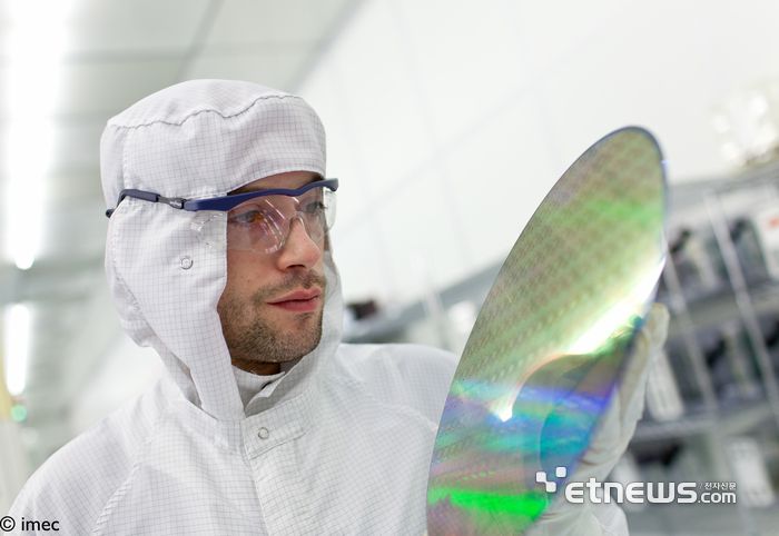 아이멕(imec) 클린룸에서 연구원이 웨이퍼를 들고 있다.