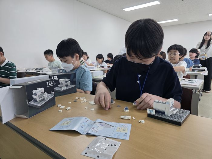 참가자들이 도쿄일렉트론 식각 장비 'Tactras' 블록 모형을 조립하고 있다.