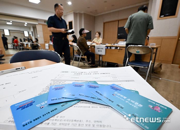 이재명 정부 첫 대규모 경기부양책인 민생회복 소비쿠폰(민생쿠폰) 신청 첫 날인 21일 서울 양천구 신정3동주민센터에서 시민들이 접수를 하고 있다. 민생쿠폰은 오는 9월 12일까지 온·오프라인을 통해 1차 신청을 받는다. 지원금액은 국민 1인당 기본 15만원이며 차상위 계층과 한부모가족은 1인당 30만원, 기초생활수급자는 1인당 40만원을 받는다.  이동근기자 foto@etnews.com