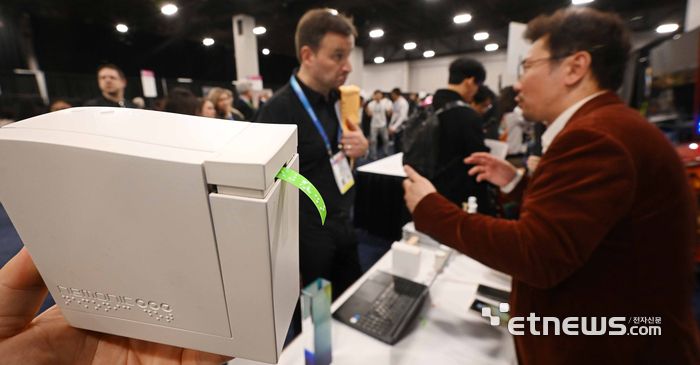 세계 최대 가전·정보기술(IT) 전시회 'CES 2026'이 오는 6일부터 나흘 간 미국 네바다주 라스베이거스 일대에서 열린다. 개막을 이틀 앞둔 4일(현지시간) 라스베이거스 만달레이베이 컨벤션센터에서 열린 CES 언베일드(Unveiled)에서 참관객이 망고슬래브의 AI 점자 프린터 '네모닉'을 살펴보고 있다.  라스베이거스=이동근기자 foto@etnews.com