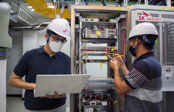 SK텔레콤과 SK브로드밴드 엔지니어가 유무선 통합 허브를 점검하는 모습. [사진=SK텔레콤]