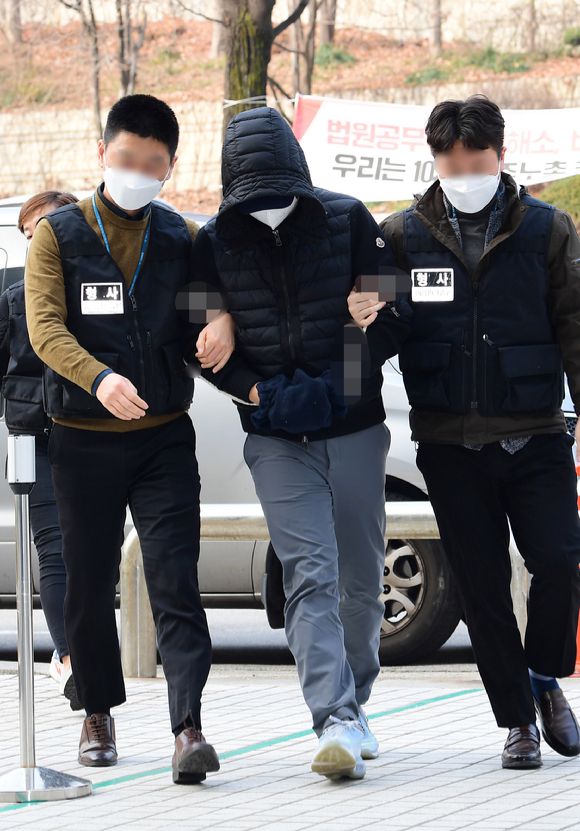 수십여 명의 여성과의 성관계 장면을 불법촬영한 혐의로 긴급체포된 모 기업 회장 아들이 지난 2021년 12월11일 오후 서울 서초구 서울중앙지방법원에서 구속 전 피의자 심문(영장실질심사)를 받기 위해 법정으로 들어서고 있다.  [사진=뉴시스 ]