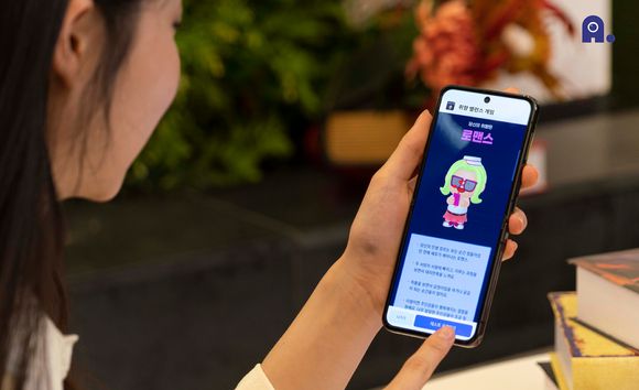 SK텔레콤은 5대 사업군의 견고한 실적 상승세를 기반으로 2023년을 AI 컴퍼니 도약과 전환의 원년으로 삼고 가시적인 성과 창출에 나선다고 밝혔다. 사진은 모델이 SK텔레콤 'A. (에이닷)'의 'A. game' 내 기능을 체험하고 있는 모습. [사진=SK텔레콤]