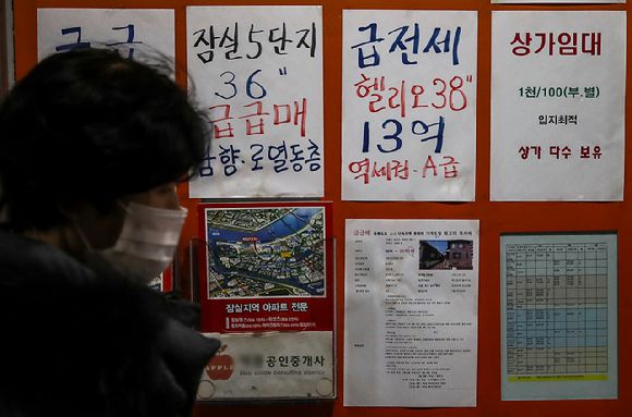 서울시내 부동산 앞에서 한 시민이 이동하고 있다.  [사진=뉴시스]