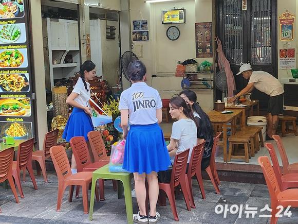 하이트진로 베트남 판촉원들이 11일(현지시간) 베트남 하노이 따히엔 맥주거리에서 현지 소비자를에게 소주 음용을 권하고 있다. [사진=전다윗 기자]