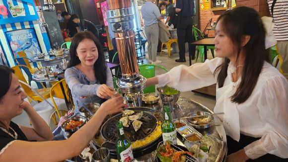 11일(현지시간) 베트남 하노이 따히엔 맥주거리 진로BBQ에서 소주를 마시고 있는 부 티 탐(오른쪽)씨와 친구들. [사진=하노이 공동취재단]