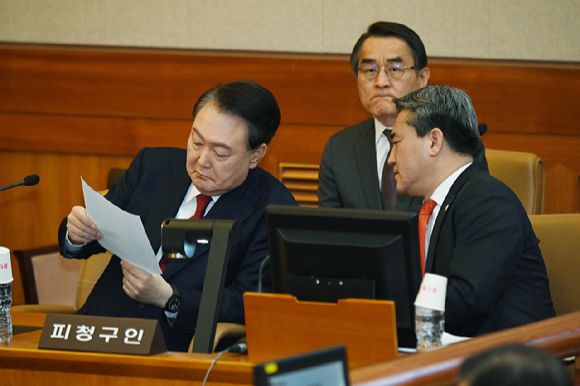 윤석열 대통령이 지난 6일 서울 종로구 헌법재판소 대심판정에서 열린 탄핵 심판 6차 변론에 출석해 변호사와 대화를 하고 있다. [사진=사진공동취재단]