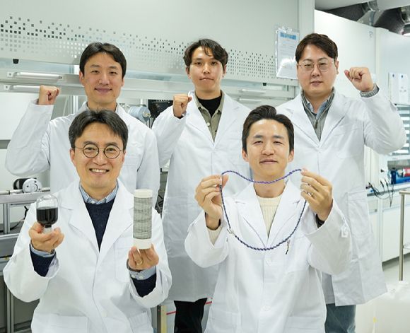 KERI 한중탁 박사와 KIMS 김태훈 박사(앞줄 왼쪽부터)를 비롯한 연구팀이 각각 CNT 용액과 와이어, 목걸이형 슈퍼커패시터를 들고 포즈를 취하고 있다. [사진=전기연]