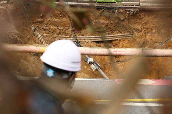 25일 강동구 대명초등학교 도로에서 전날 발생한 대형 땅꺼짐 현장의 모습. 명일동 대명초등학교 인근 사거리에서 발생한 지름 20ｍ, 깊이 18ｍ가량의 대형 싱크홀(땅꺼짐)에 오토바이 운전자 1명이 빠져 실종됐다. 2025.3.25 [사진=연합뉴스]