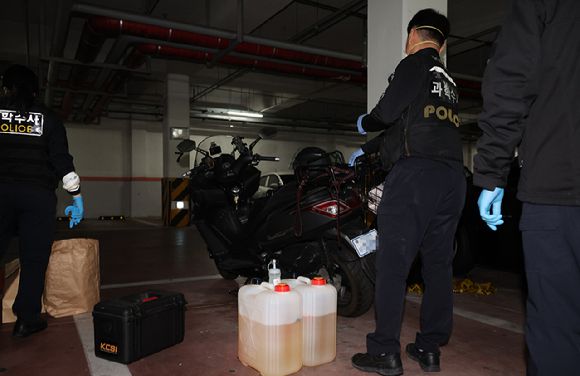 21일 서울 관악구 봉천동 한 아파트에 화재가 발생해 과학수사대원들이 아파트 지하주차장에서 유력용의자가 사용한 것으로 추정되는 인화물질과 오토바이를 감식하고 있다. [사진=연합뉴스]