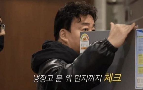타 식당 주방 냉장고 먼지를 체크하고 있는 백종원 더본코리아 대표. [사진=유튜브 캡처]