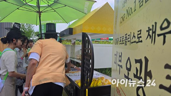 2025 올리브영 페스타에 마련된 한 부스에서 소비자가 이벤트를 참여해 상품을 받고 있다. [사진=진광찬 기자]