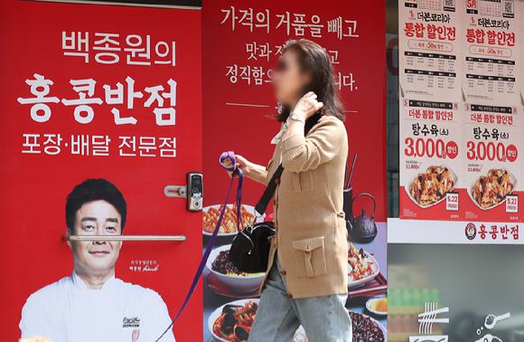 지난 13일 서울 시내 한 홍콩반점0410 매장에 할인 안내문과 백 대표 사진이 붙어 있다. [사진=연합뉴스]