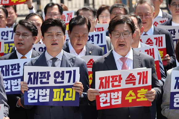 국민의힘 김용태 비상대책위원장과 권성동 원내대표가 11일 이재명 대통령의 공직선거법 위반 사건의 파기환송심을 사실상 무기한 연기한 서울고등법원 앞에서 열린 현장 의원총회에서 구호를 외치고 있다. [사진=연합뉴스]