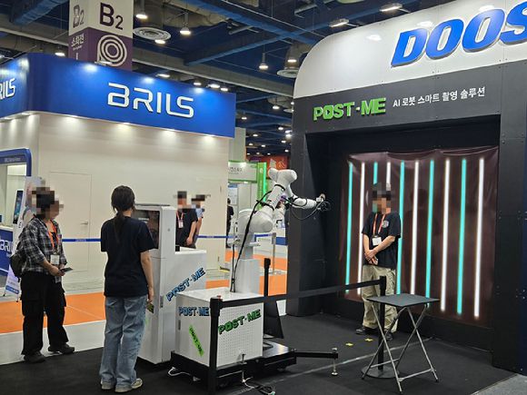 '스마트테크 코리아 2025' 두산로보틱스 부스에서 관람객이 사진을 찍고 있다. [사진=최란 기자]