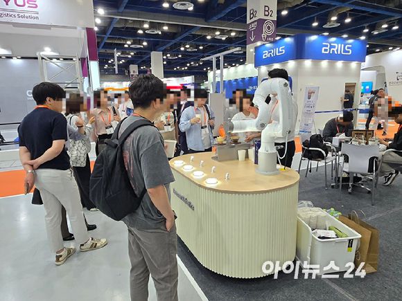 '스마트테크 코리아 2025' 두산로보틱스 부스에서 관람객들이 설명을 듣고 있다. [사진=최란 기자]