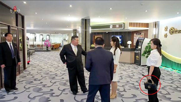 김정은 북한 국무위원장의 아내 리설주 여사가 이탈리아 명품 브랜드 '구찌'(붉은 원)로 추정되는 검은색 핸드백을 멘 모습이 포착됐다. [사진=조선중앙TV화면]
