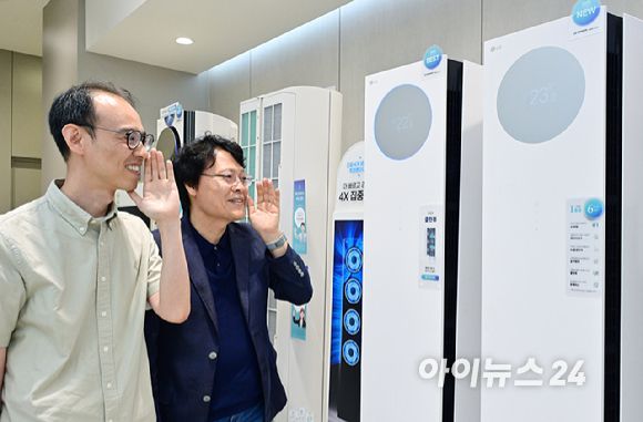 LG전자 박재성 책임(왼쪽)과 김락용 연구위원이 22일 서울 영등포구 더현대에 자리한 LG전자 매장에서 에어컨 신제품의 AI 음성인식 기능을 선보이고 있다. [사진=LG전자]