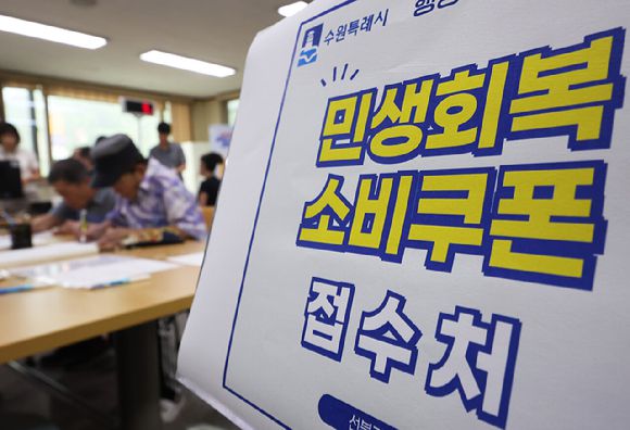 민생회복 소비쿠폰 1차 신청 첫날일 지난 21일 경기도 수원시 시민들이 소비쿠폰을 신청하고 있다.  [사진=연합뉴스]