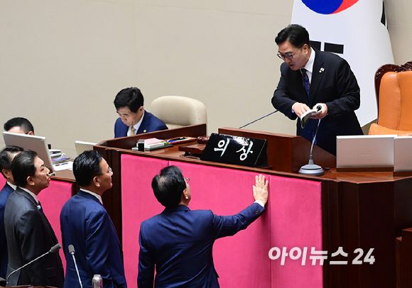 우원식 국회의장이 25일 서울 여의도 국회에서 열린 제429회 국회(정기회) 제9차 본회의에서 '민주유공자 예우 법률안 신속처리안건 지정동의의 건' 투표 중 명패와 투표지 갯수 1개차 불일치가 발생한 것에 대해 항의하는 송언석 국민의힘 원내대표에게 국회법을 보여주며 해결방안을 설명하고 있다. [사진=정소희 기자]