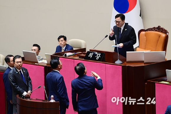 우원식 국회의장이 25일 서울 여의도 국회에서 열린 제429회 국회(정기회) 제9차 본회의에서 '민주유공자 예우 법률안 신속처리안건 지정동의의 건' 투표 중 명패와 투표지 갯수 1개차 불일치가 발생한 것에 대해 항의하는 송언석 국민의힘 원내대표에게 국회법을 보여주며 해결방안을 설명하고 있다. [사진=정소희 기자]