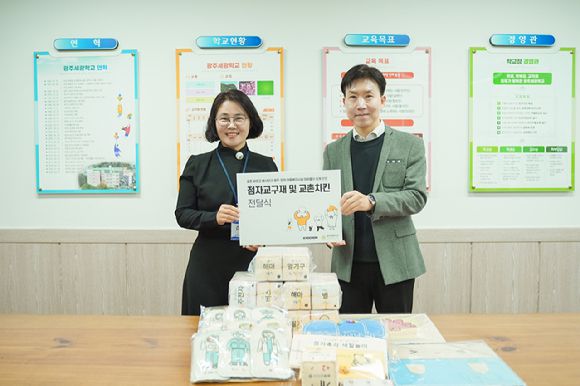 지난 11월 말 광주광역시 서구 광주세광학교에서 열린 점자 교구재 전달식에서 임형욱(오른쪽) 커뮤니케이션전략실장과 권연희 광주세광학교 교감이 기념 촬영을 하고있다. [사진=교촌에프앤비]