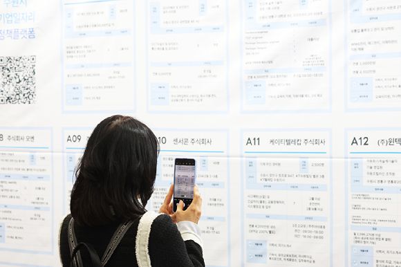 지난해 4월 9일 경기도 수원시 영통구 수원컨벤션센터에서 열린 '수원 일자리 박람회'에서 구직자가 채용 게시판을 휴대전화로 찍고 있다.  [사진=연합뉴스]